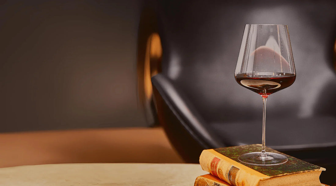 Zalto Bordeaux glass with red wine resting on antique books